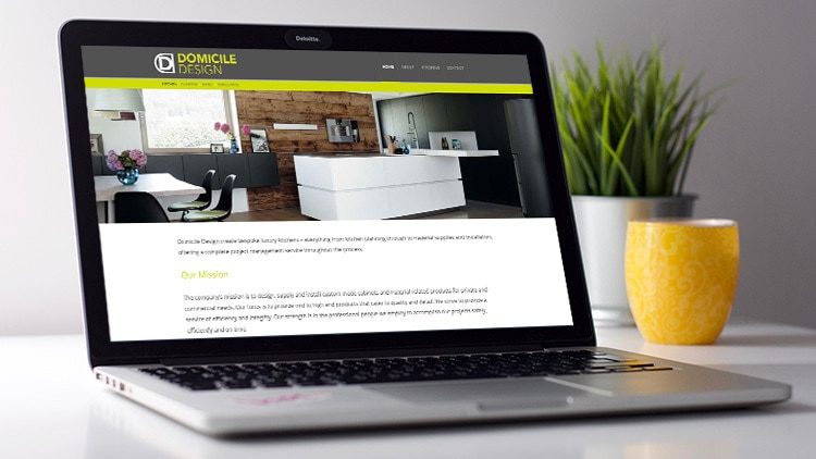 Domicile Design website on laptop screen with plants in background