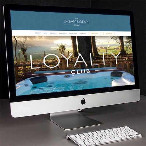 Desk lamp facing desktop computer displaying homepage of Dream Lodge Loyalty website design Thumbnail