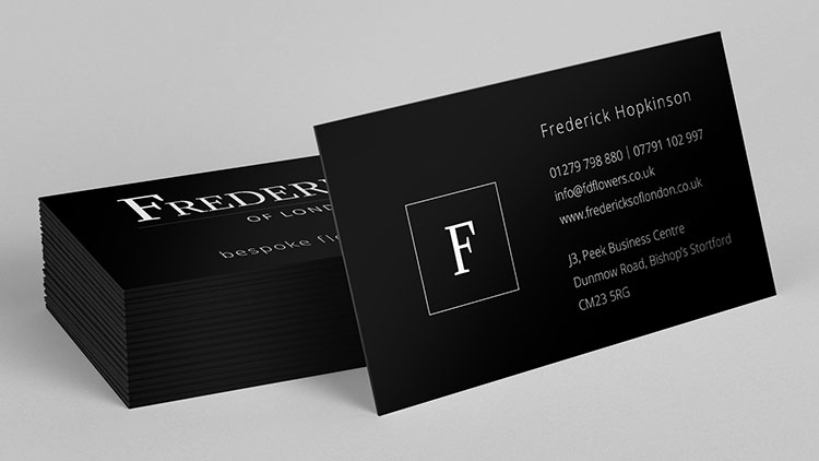 Business card resting on stack of business cards for Fredericks of London branding design