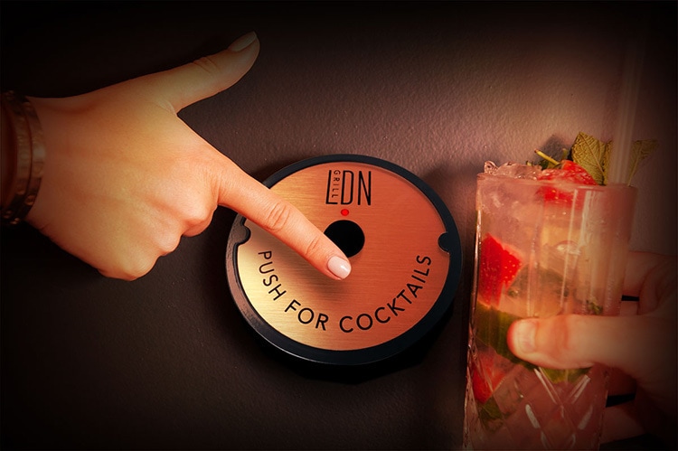 Person hovering Push for Cocktails button for LDN Grill retail design