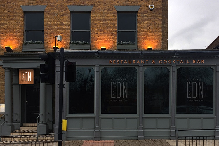 Front of Restaurant with copper signage and window decal with illuminated signage for LDN Grill branding