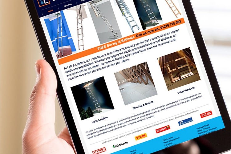 A person holding a tablet viewing the Loft & Ladders responsive website design