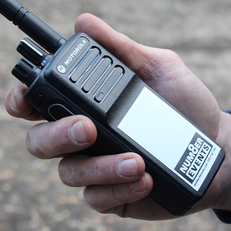 A Person holding a Walkie Talkie with Number 8 Events Branding