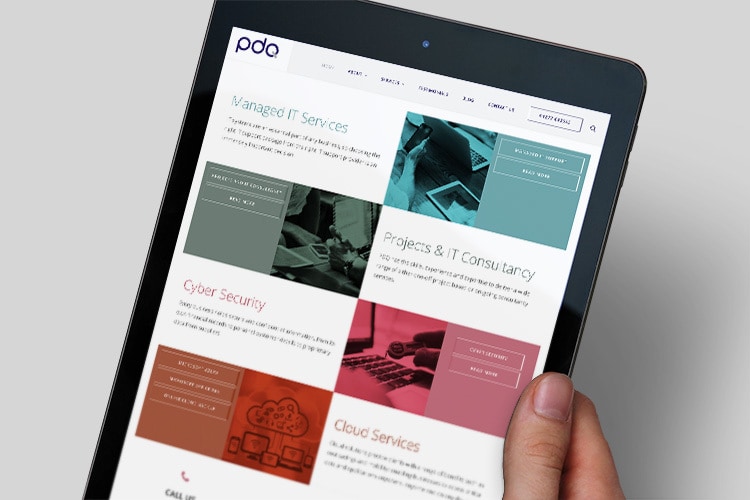 A person holding a tablet viewing the new responsive website design for PDQ