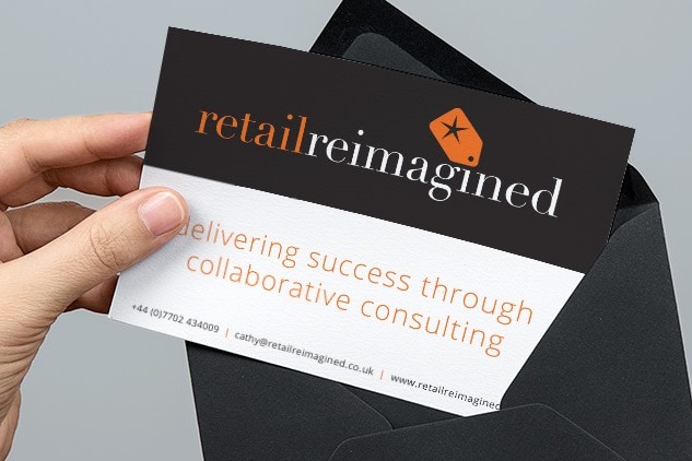 A person pulling out the Retail Reimagined postcard print design