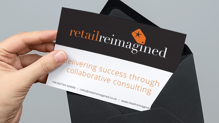 A person pulling out the Retail Reimagined postcard print design