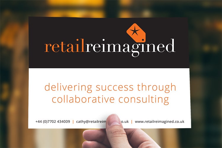 A person holding Retail Reimagined postcard print design