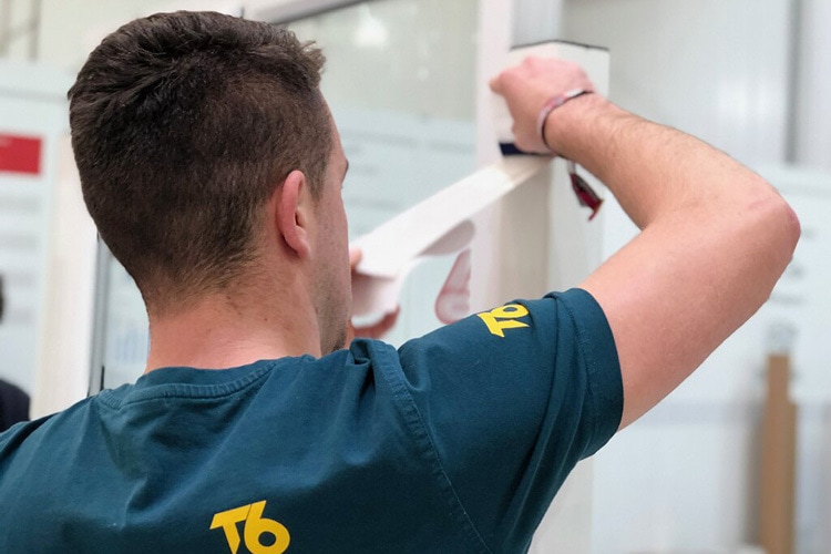 A person wearing T6 branded T-shirt applying tape photography for T6 website