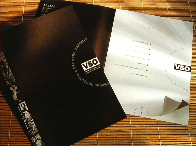Black front cover and open spread brochure design for VSO annual accounts