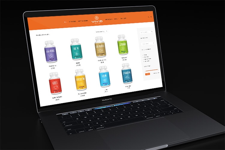 Laptop in a dark room displaying the Vivid Health responsive eCommerce shop page website
