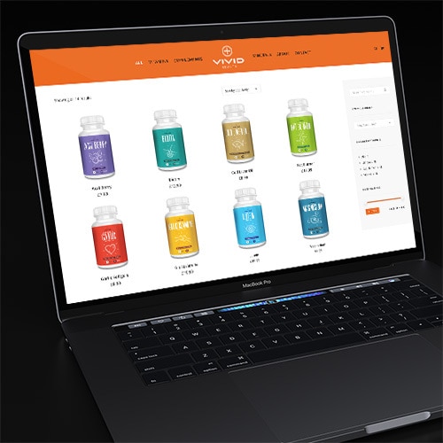 Laptop in a dark room displaying the Vivid Health responsive eCommerce shop page website Thumbnail