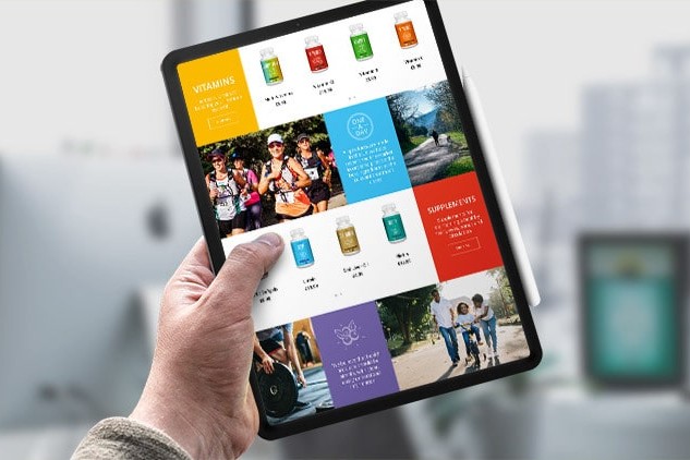 A person holding a tablet displaying the Vivid Health responsive eCommerce shop page website