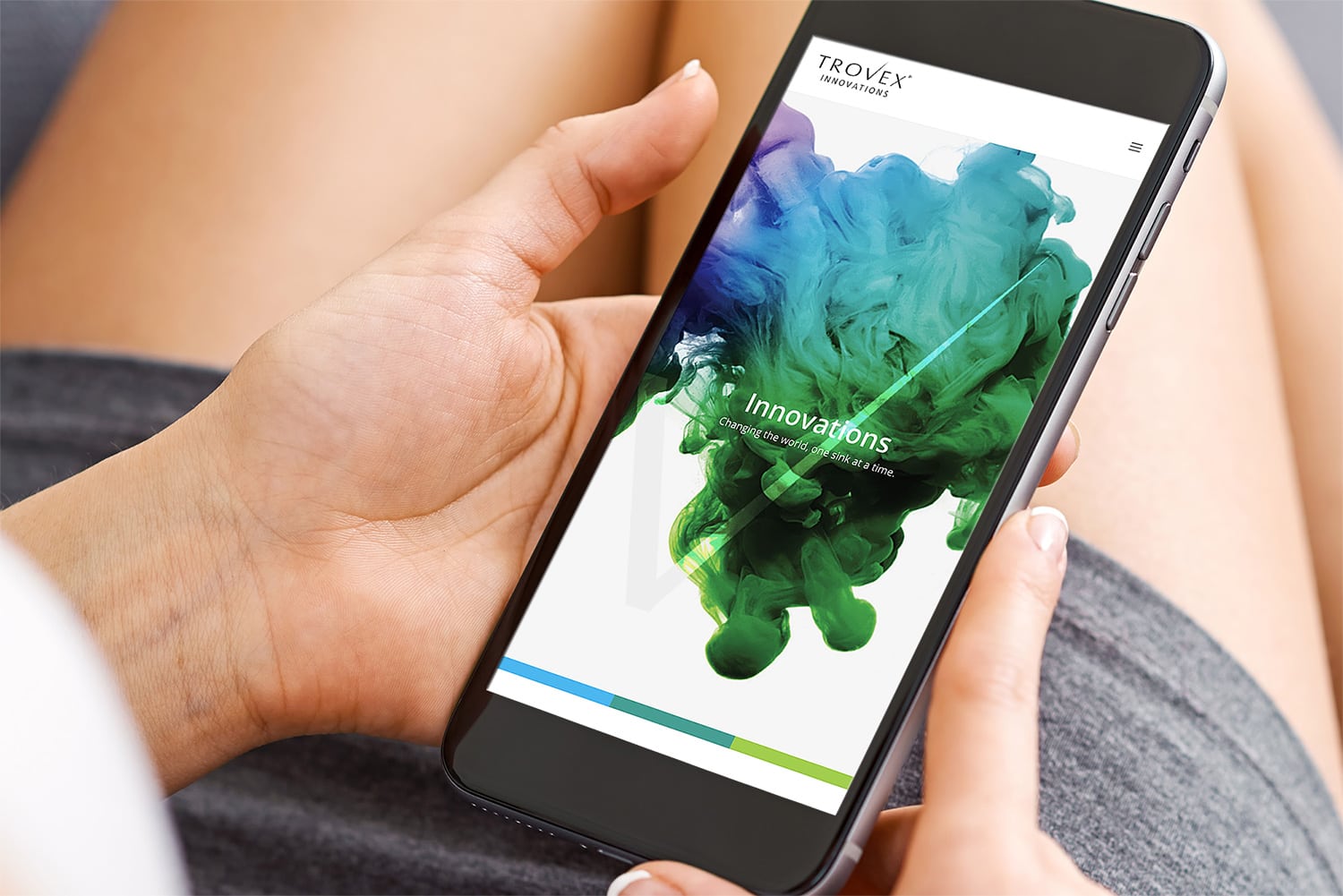 Person holding mobile phone, viewing the responsive Trovex Innovations website design